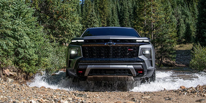 Gray chevy traverse running offroading near river area